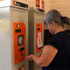 Una passatgera a les taquilles de l'estació de Caldes de Malavella