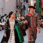 Una parella participant a l'entrega d'estandards de les famílies nobles de la Festa del Renaixament es miren mentre es dirigeixen als Reials Col·legis de Tortosa.