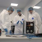 El conseller de Presidència, Albert Dalmau, amb el fundador d'Open Cosmos, Rafael Jordà, davant del nanosatèl·lt 6gStarLab