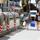 Dues dones passen pel costat dels contenidors mentre van a la platja a Salou.