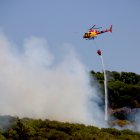Un helicòpter descarrega aigua en un incendi forestal a Alforja.