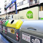 Imatge d’arxiu d’un treballador de la neteja manipulant uns contenidors.