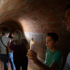 Visitants llegint missatges escrits a les parets del refugi antiaeri de la Patacada.