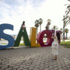 Una turista fent una foto a les lletres de Salou
