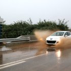 Un cotxe creua un bassal d'aigua i fang a la C-12