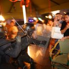 Dos agents dels Mossos d'Esquadra carreguen contra dos manifestants en la protesta al centre de Barcelona en solidaritat amb Palestina.