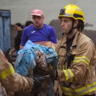 Bombers treballen per netejar el fang i retirar brossa dels carrers i les cases de Godall