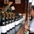 Una dona compra vi en una de les casetes de la 38a festa del Vi de Gandesa