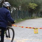 Un ciclista llegint el cartell que indica la prohibició d'accedir a Collserola a la carretera de les Aigües de Barcelona.