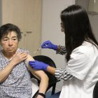 Imatge d’arxiu d’una professional vacunant una pacient de la grip i la covid