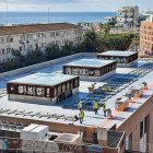Imatge dels operaris instal·lant les plaques solars a la coberta del Palau Firal.
