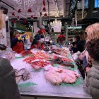 Clients compren en una parada de peix del Mercat Central de Reus.