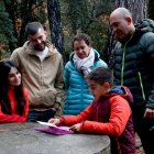 Diversos familiars de l'Anna observen les il·lustracions que va fer.