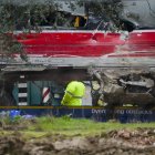 Una grúa trabaja en el vagón 8 del tren Iryo, el último vagón que chocó al descarrilar contra el Alvia que se dirigía a Huelva.