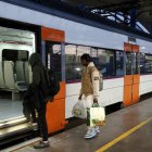 Viatgers pujant a un tren de Rodalies a l'estació de Lleida.