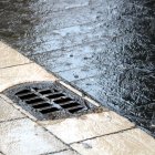 Detall d'un embornal engolint la pluja.