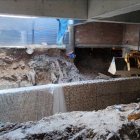 Imatge d'una excavadora als baixos on s'amaga la Font dels Lleons, després que les obres s'aturessin.