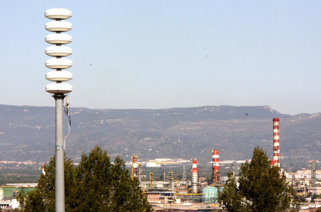 Imatge d'arxiu d'una de les sirenes de risc d'accident químic, amb el polígon petroquímic nord de Tarragona, al fons.