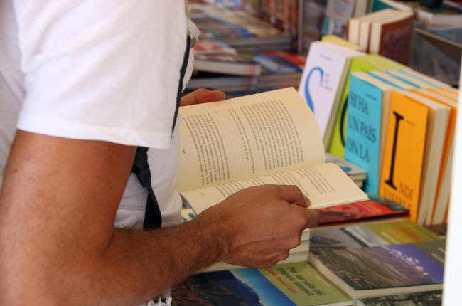 Una persona fulleja un llibre durant la darrera edició de la Setmana del Llibre en Català.