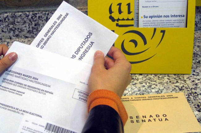 Imatge d'arxiu en la qual una ciutadana deposita el seu vot per correu en una oficina postal.