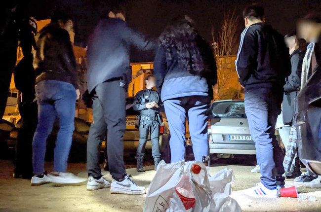 Agents de la Guàrdia Urbana de Reus, de nit, denunciant un grup de joves per consumir alcohol a la via pública.