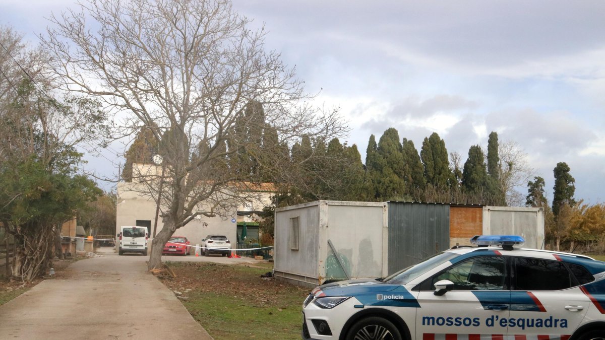 La casa custodiada con un vehículo policial.
