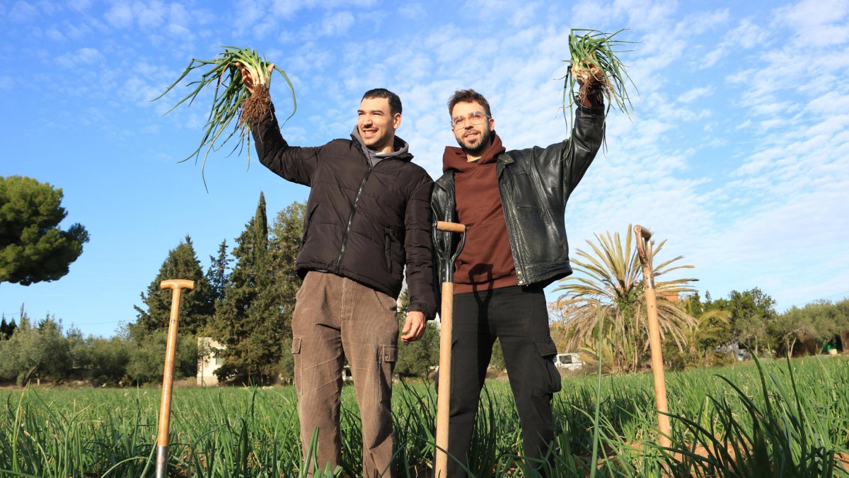 Los integrantes de Figa Flawas alzan un manojo de calçots.