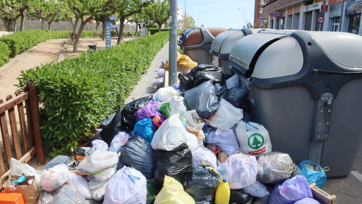 Una bateria de contenidors amb la brossa per terra després de cinc dies de vaga dels treballadors de la recollida d'escombraries a Torredembarra.