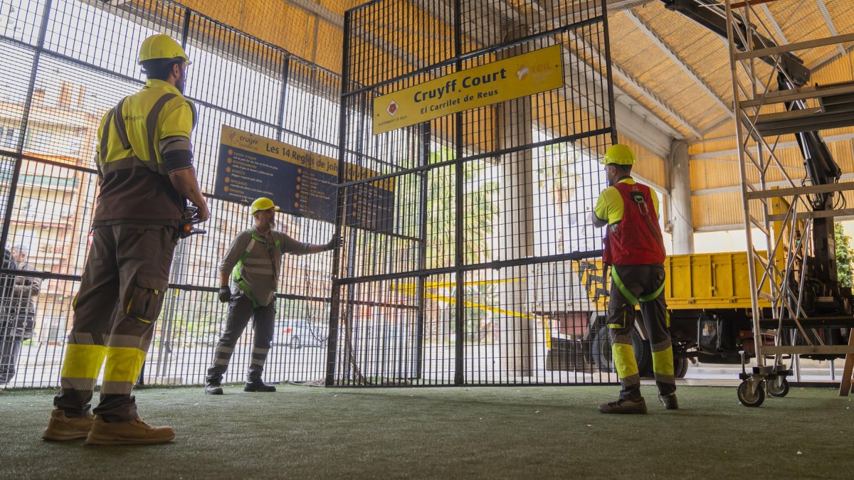 Fotografia dels operaris, enretirant elements del terreny de joc.