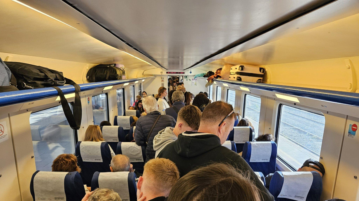 Imatge d'un tren, amb parada a Tarragona, ple de passatgers.
