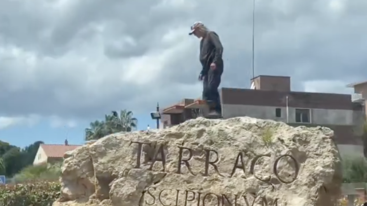 Imagen del hombre subido a la piedra de la rotonda de la Vía Augusta.