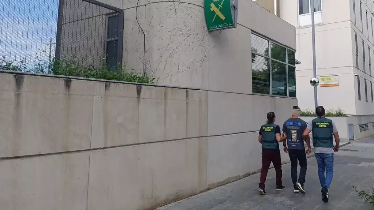 Uno de los detenidos custodiado por dos agentes de la Guàrdia Civil.
