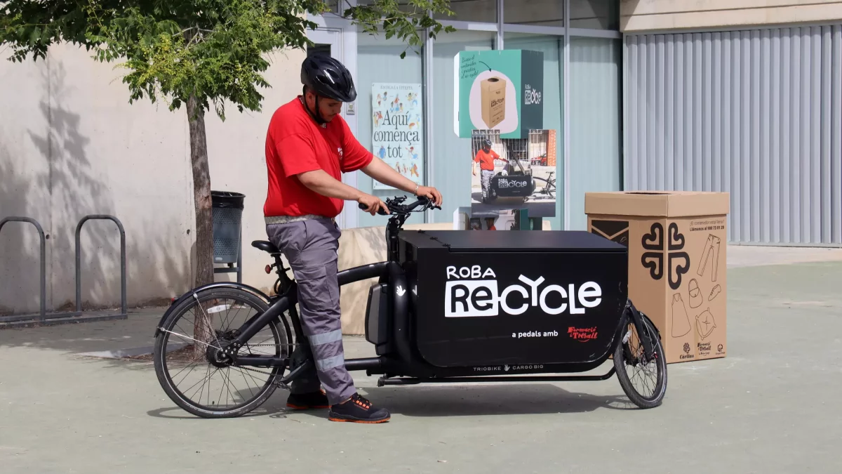 Imagen de la bicicleta de carga que transporta la ropa en desuso depositada a los contenedores de siete escuelas de Reus.