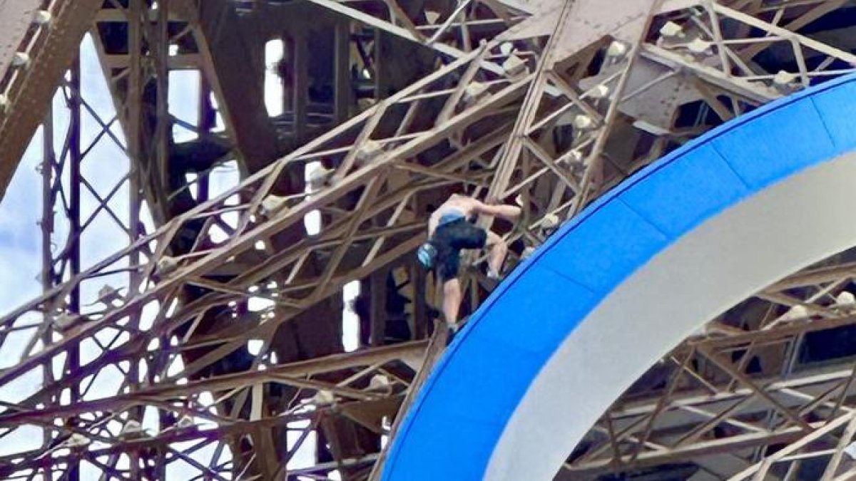 Imatge de l’home escalant la Torre Eiffel