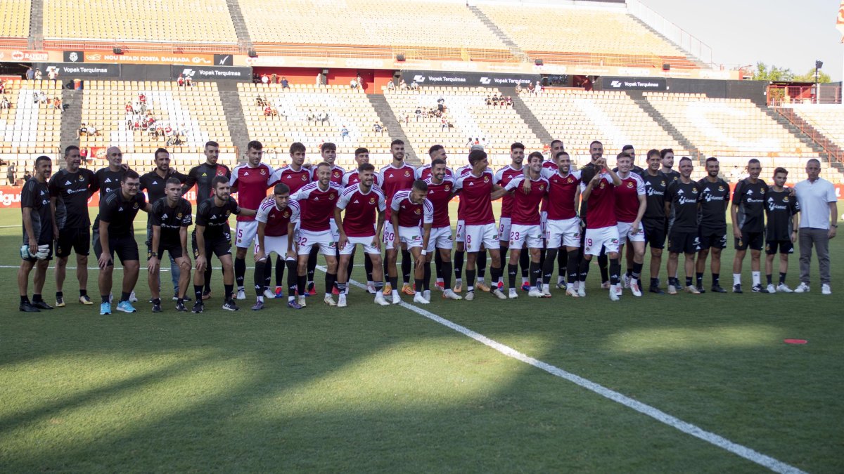 El cuerpo técnico y los jugadores del Nàstic de Tarragona sobre el césped del Nuevo Estadio Costa Daurada antes del partido de presentación contra el SD Huesca en el trofeo Ciudad de Tarragona