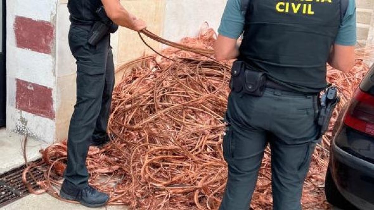 Dos agentes con los cables sustraídos.