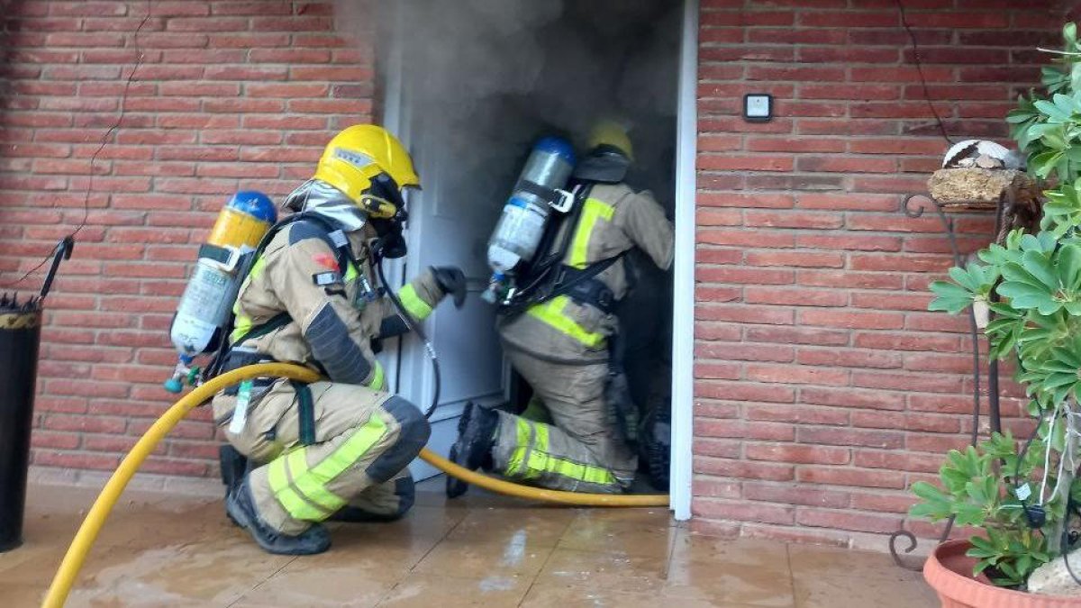 Bombers treballant en l'incendi d'un habitatge de Cala Romana.