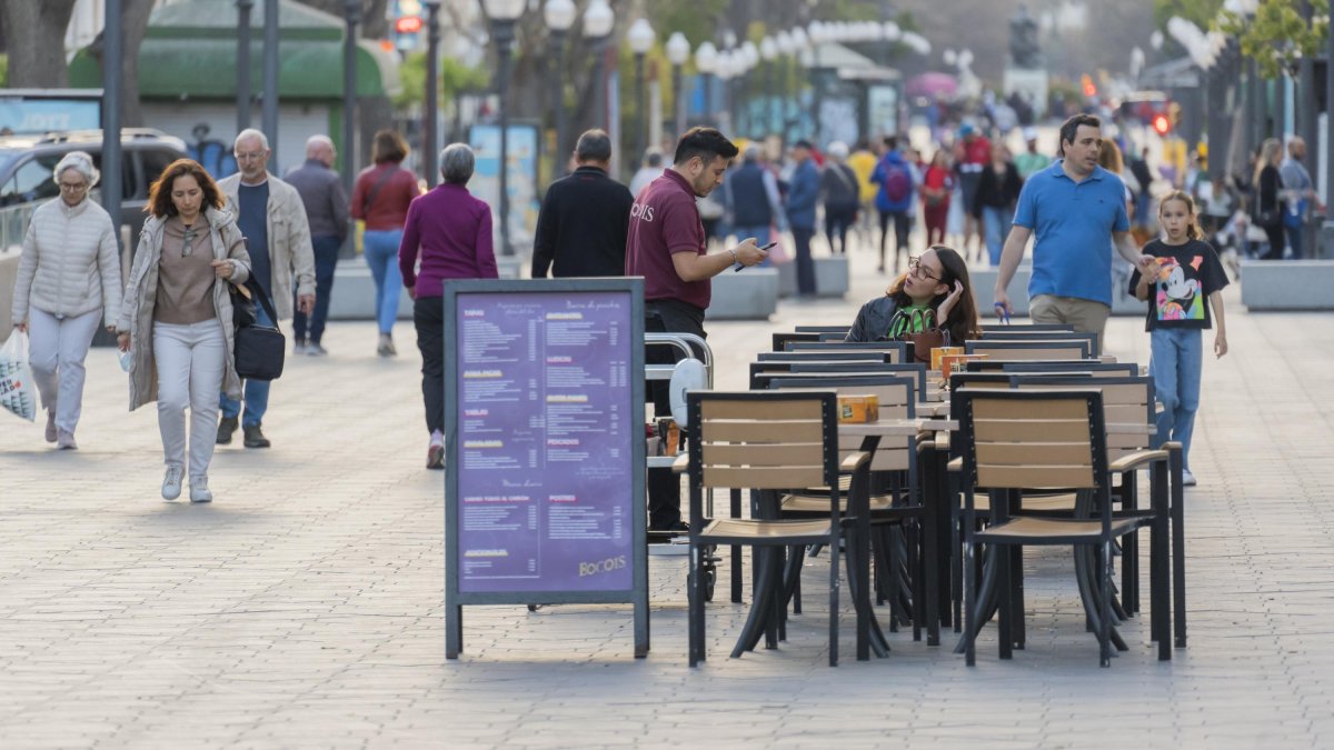 Un cambrer atenent una taula a un restaurant de la Rambla Nova de Tarragona.