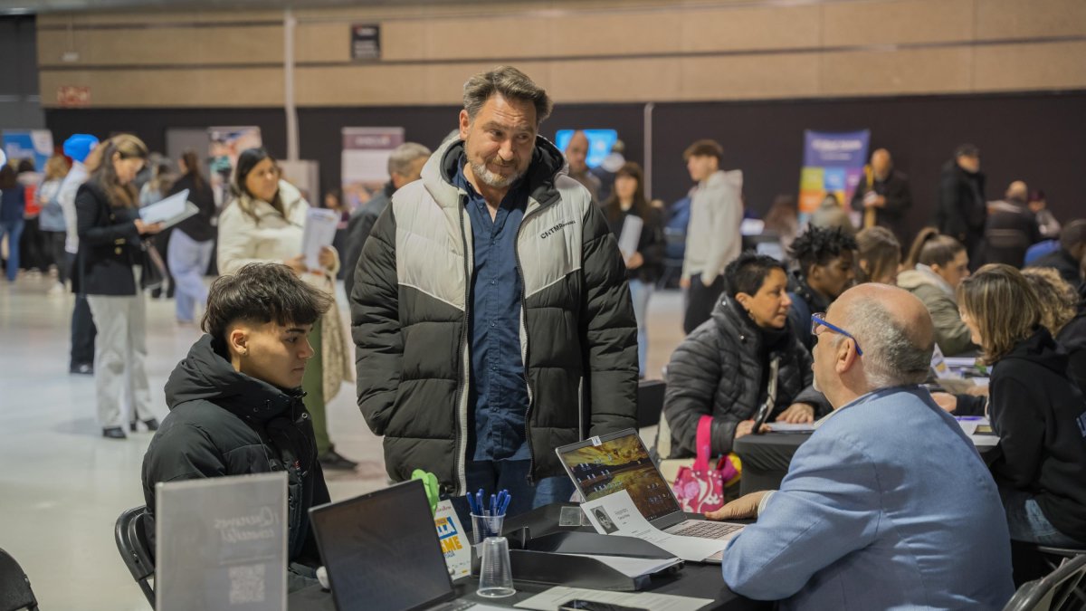 Fotografia d’un expositor de la Jornada Treballa al Turisme atenent a un visitant.