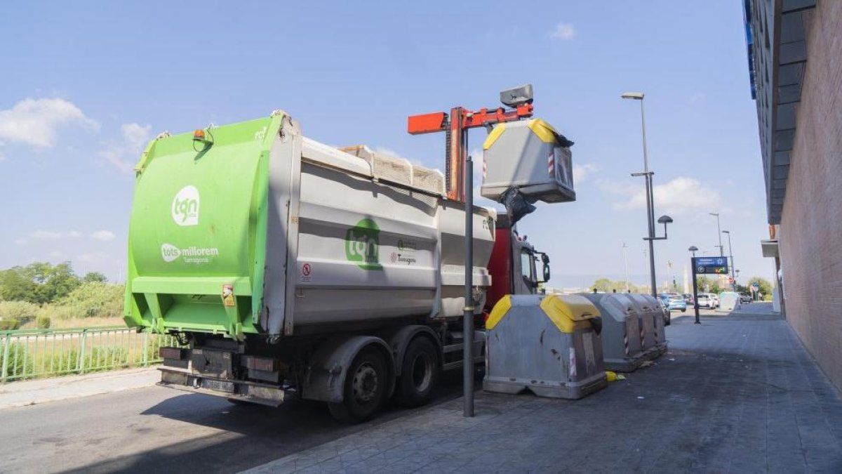 Un camió de la brossa agafant un contenidor al passeig de la Independència