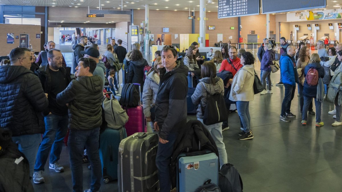 Imagen de archivo de varios pasajeros esperando con sus maletas en el aeropuerto de Reus.