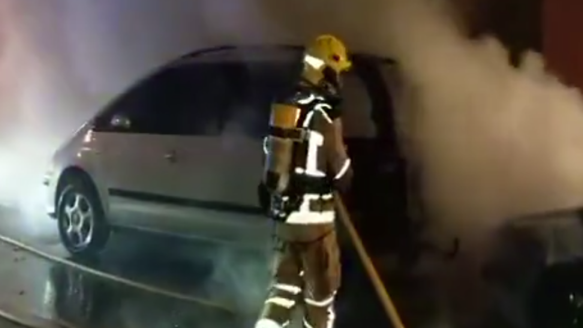 Los bomberos trabajando en la extinción del el incendio de los dos vehículos.
