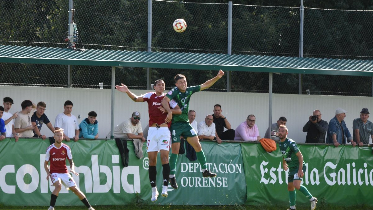El jugador del Nàstic, Pablo Fernández, luchando un duelo aéreo con Javi Moreno durante el duelo a O Carballiño.