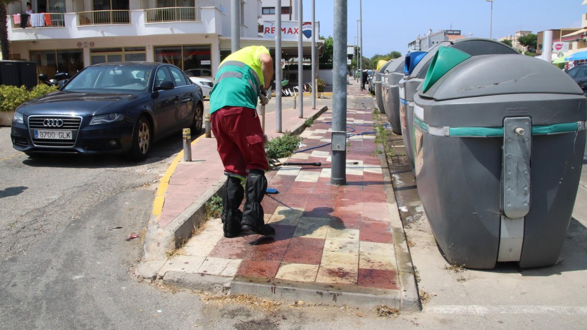 Imagen del lugar donde se produjo el apuñalamiento y un trabajador de la brigada de Cambrils limpiando las manchas de sangre que habían quedado en el suelo