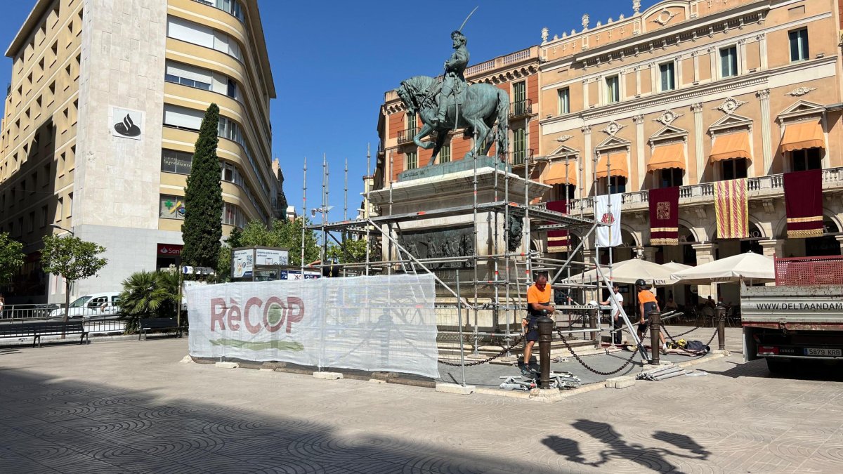 Operaris preparant-se pels treballs de neteja de la base de pedra del monument al general Prim.