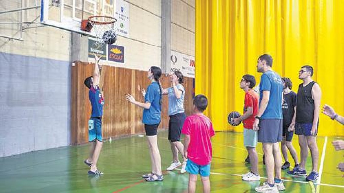 Participants del Casal Supera’t jugant a bàsquet a les instal·lacions del CN Reus Ploms.