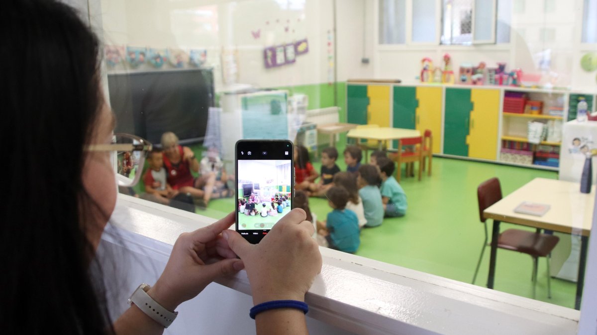 Una madre de infantil fotografía a los niños desde fuera del aula, el primer día de curso en la Escuela Vedruna Sagrat Cor.