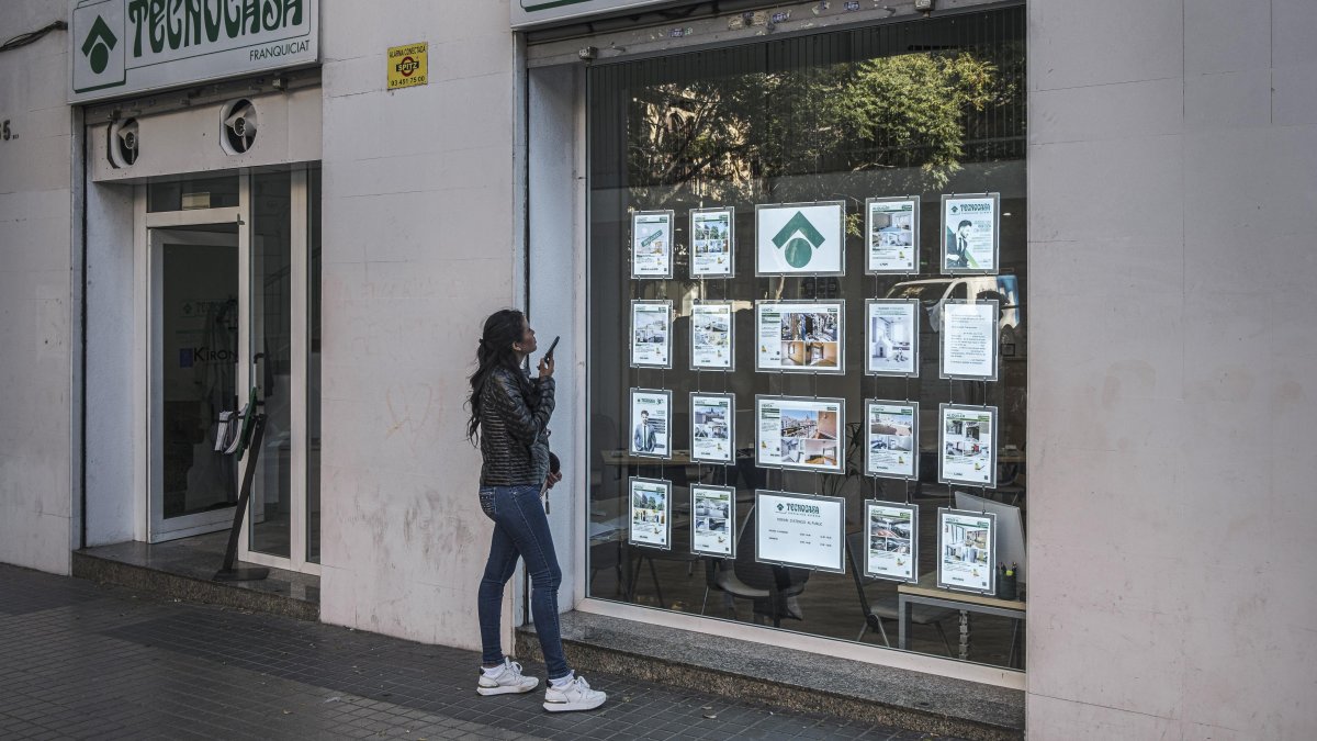 Una noia mirant anuncis de pisos en una immobiliària