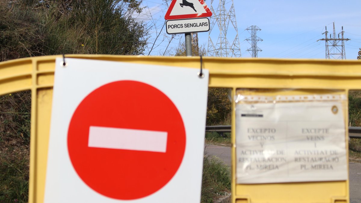 Una tanca prohibeix el pas en una carretera a Sant Just Desvern, davant un senyal que informa de presència de senglars.