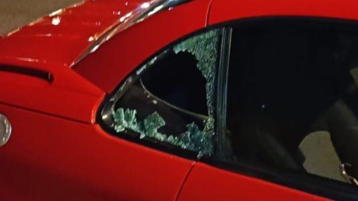 Imagen del vehículo con la ventana rota por el autor del robo.
